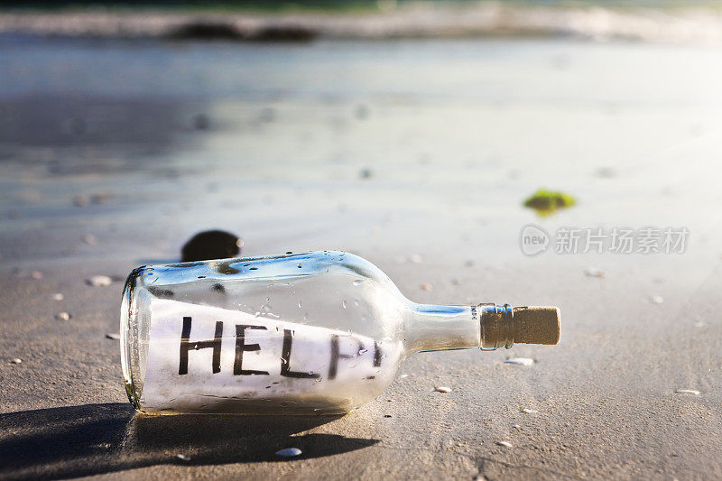 海滩上的一个瓶子上写着“救命!”