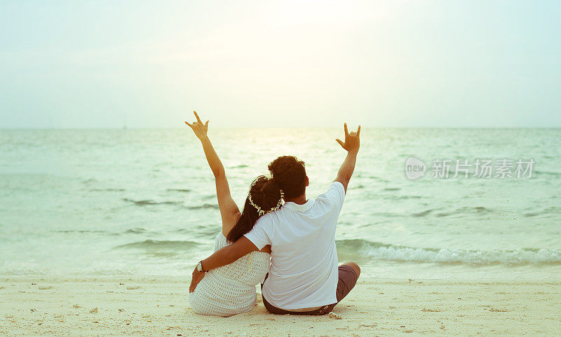 蜜月夫妇在岛上的海滩上浪漫。夕阳柔和背光