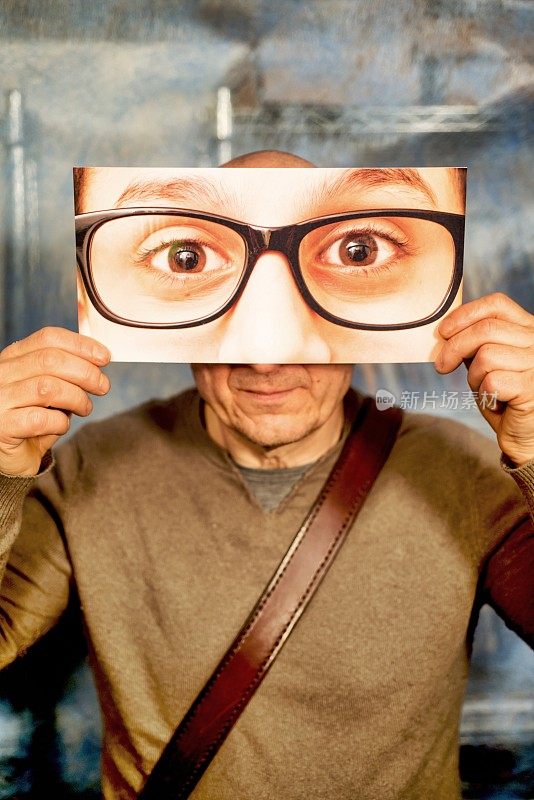戴眼镜的老人照片在他的面前
