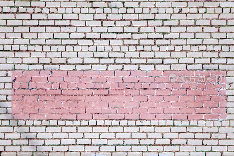 白色的砖墙上涂着粉红色的涂鸦