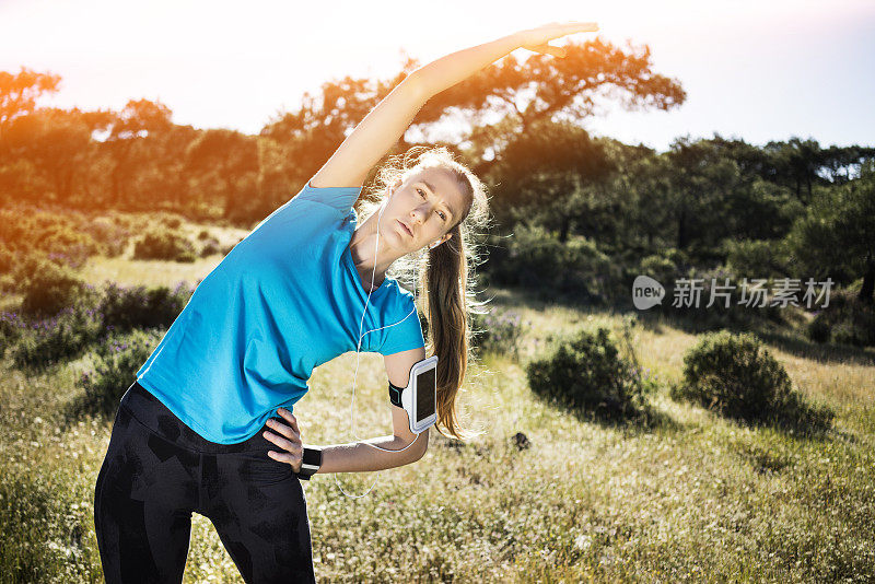 一个年轻女子在一个阳光明媚的日子里伸懒腰