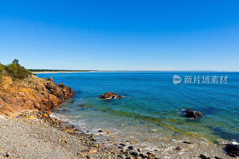 缅因州Ogunquit的岩石和海洋冲浪。蓝色的天空。