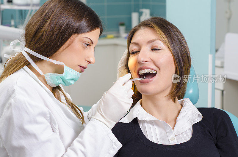 年轻的成年女子在看牙医，牙套检查