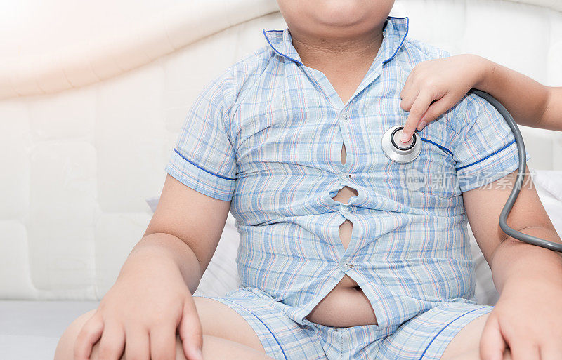 医生用听诊器给肥胖的亚洲男孩检查心脏