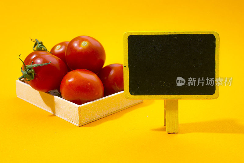 黄色背景上有樱桃番茄的空白价格板。