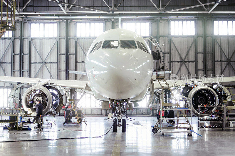 客机在机场机库进行发动机维修和机身维修。