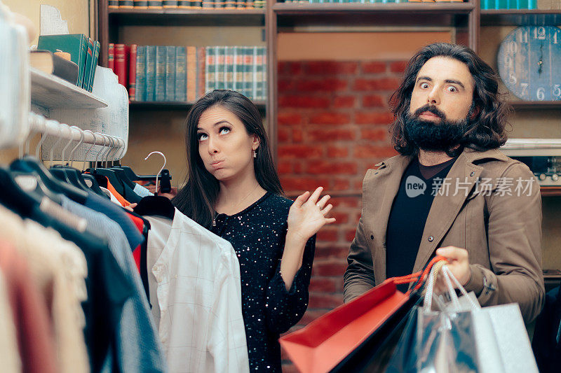 一对有趣的夫妇在服装店购物时争吵