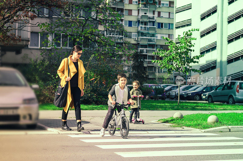 妈妈和孩子们在过马路。