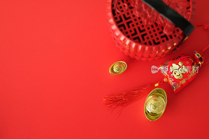 俯视图中国饰品在红色背景，红包(幸福)金元宝和红色玻璃杯，中国新年节日，复制空间。