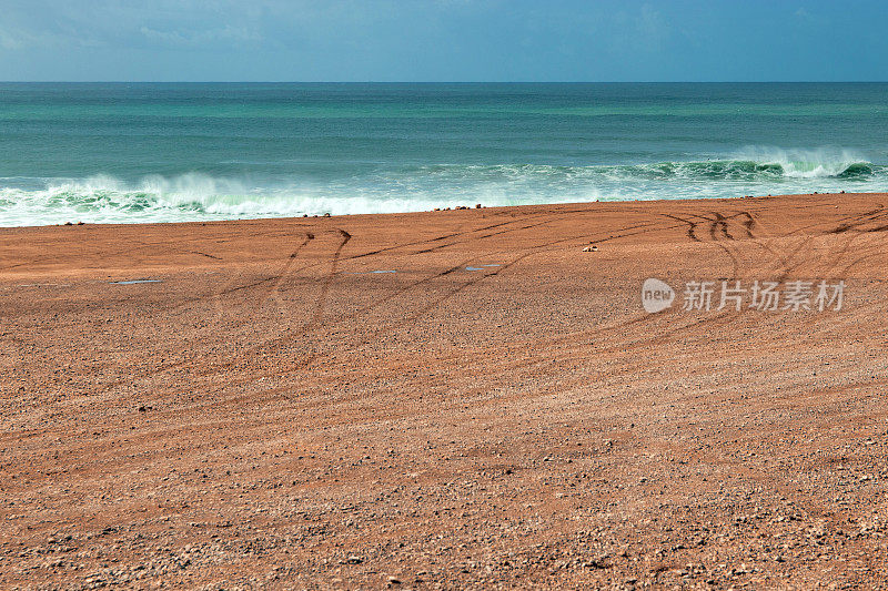 海边的轮胎印，后面是波浪