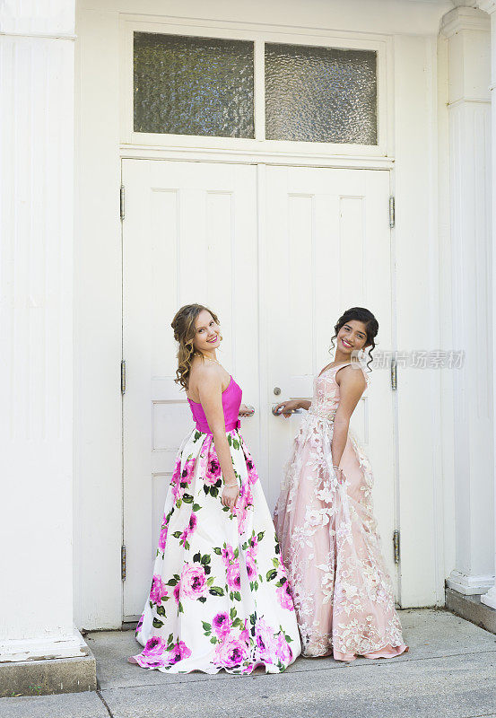 在一个美丽的春天，美国印第安纳州，两个十几岁的女孩穿着正式的派对礼服在户外玩耍