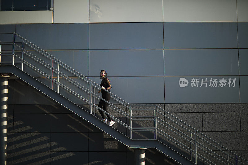 一个女人正在城市的楼梯上跑步