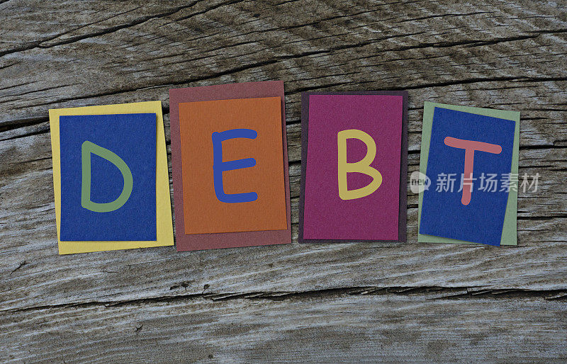 债字写在彩色的便利贴上木制的背景。