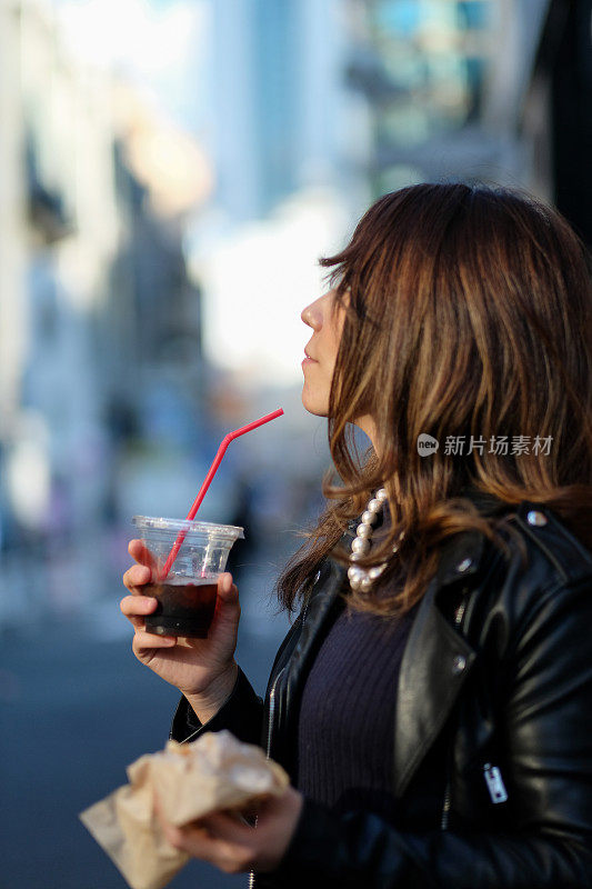 在街上喝咖啡的女人