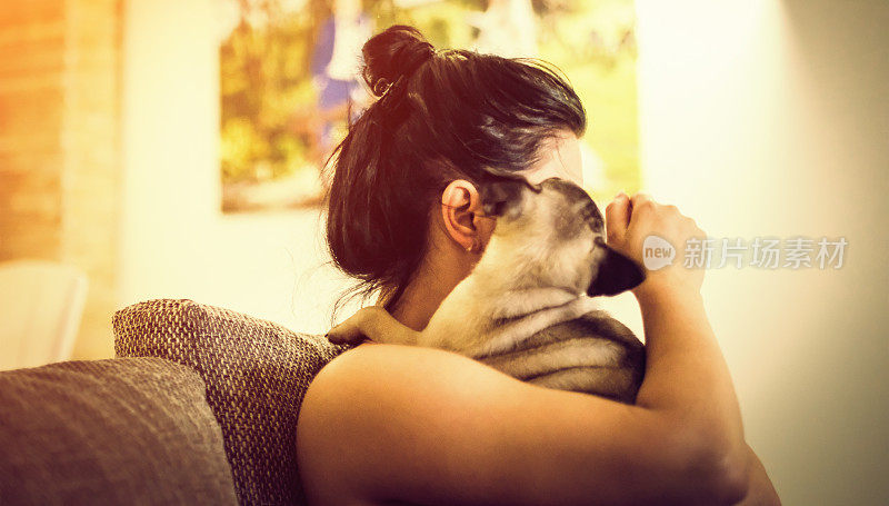一个年轻女人和一只哈巴狗坐在客厅里