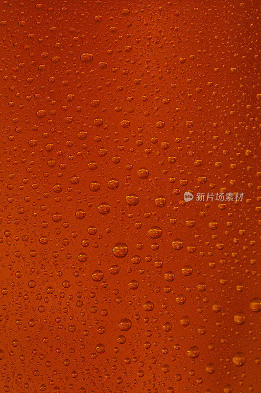 啤酒的背景。冰镇啤酒杯与水珠凝结靠近。