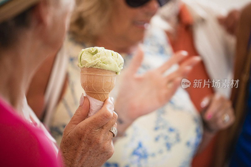 近距离拍摄的一个冰淇淋甜筒在一个年长妇女的手