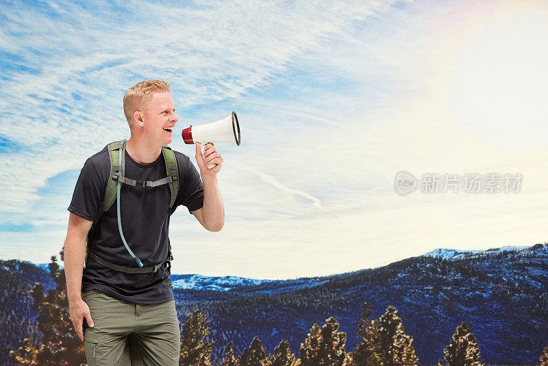 快乐的男性登山者拿着扩音器