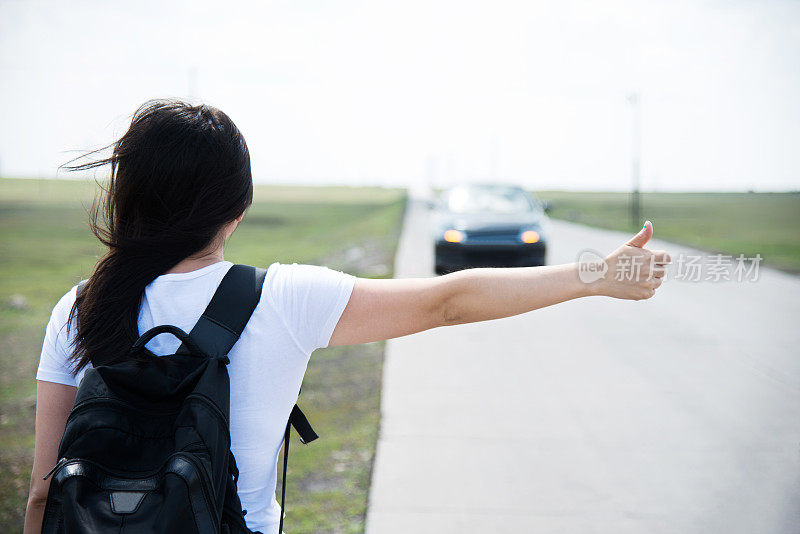 女人竖起大拇指让她搭车