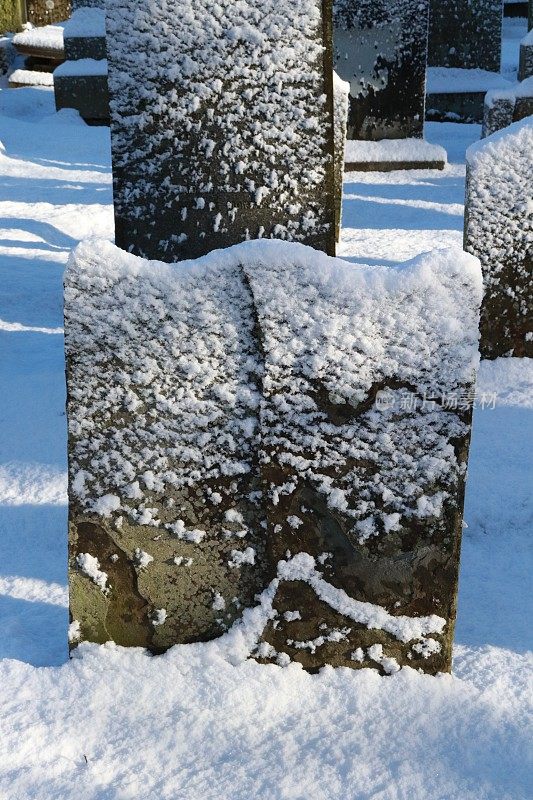 白雪覆盖的墓地里的坟墓、墓碑和墓碑