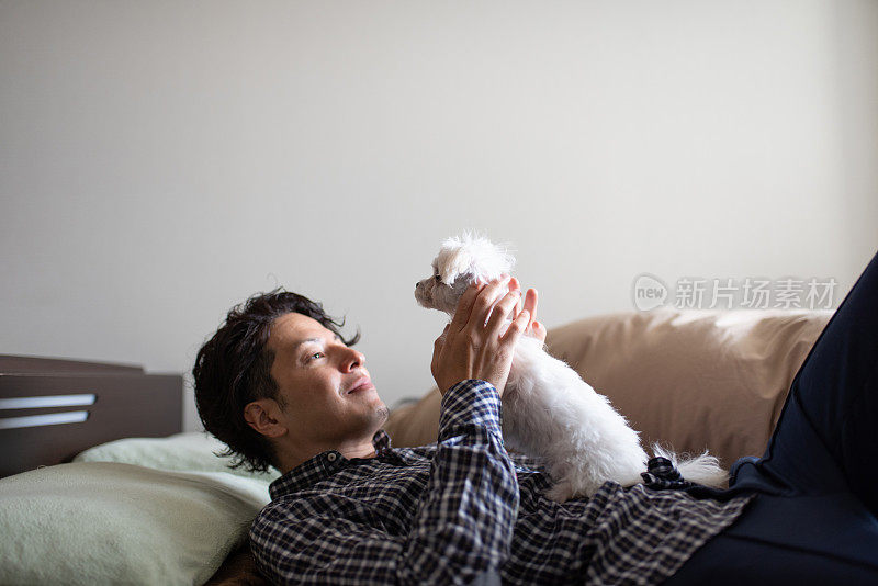男人在床上拥抱小狗