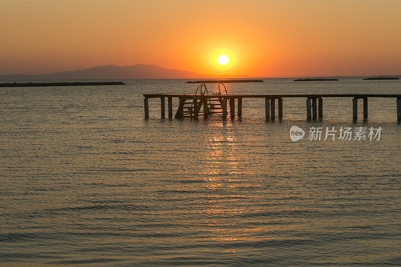 日落时分，土耳其阿瓦利克巴利克西尔阿尔蒂诺瓦夏日小镇的海滩海岸