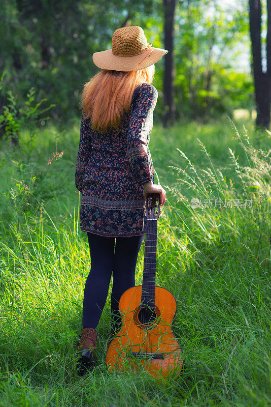 在大自然中弹奏吉他的年轻女子