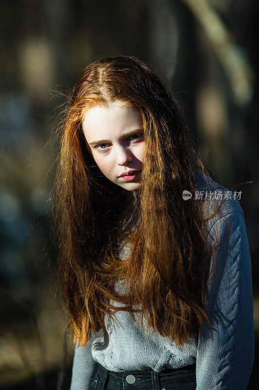 憎恨的眼神。户外漂亮的年轻女孩的肖像与明亮的红色长发。