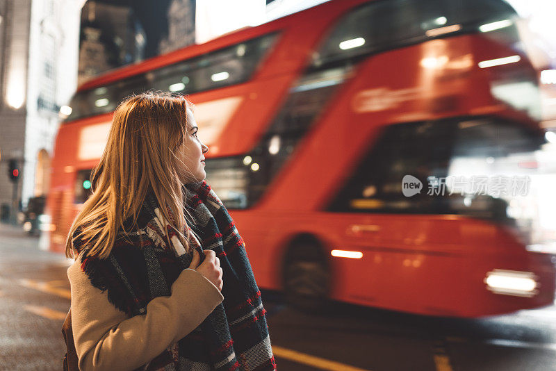 皮卡迪利广场上，一名年轻女子和一辆红色伦敦巴士