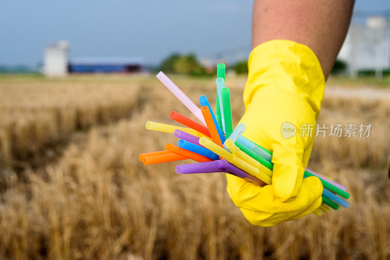 手持塑料吸管手套的手的特写——生态产业理念