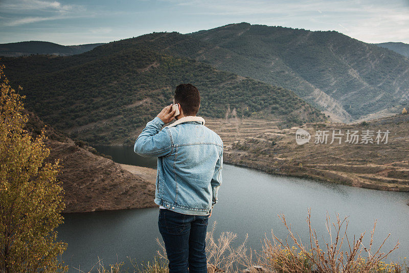 一个年轻人在一个美丽的风景里讲电话