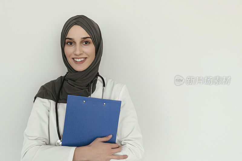 穆斯林护士拿着书写板微笑
