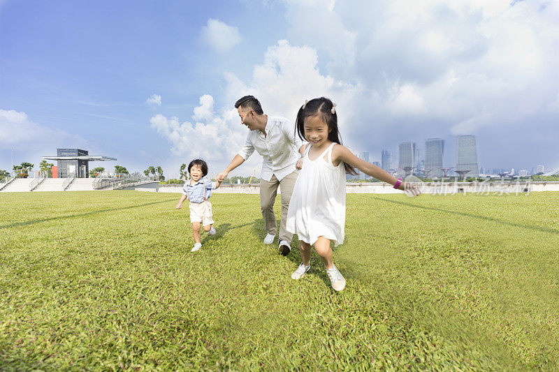 孩子们和爸爸在城市公园里跑步