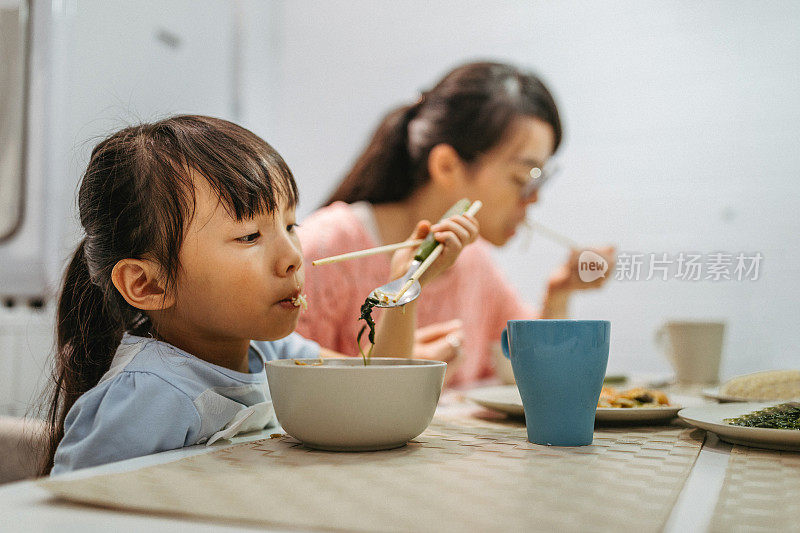 母亲和女儿在家吃中餐