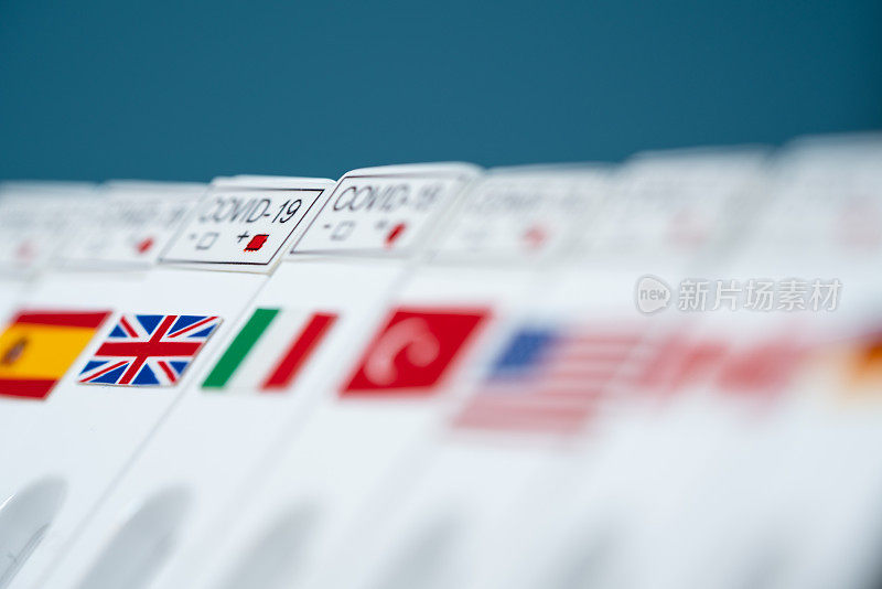 2019冠状病毒病快速检测试剂盒和英国国旗放在其他国家国旗旁边照片