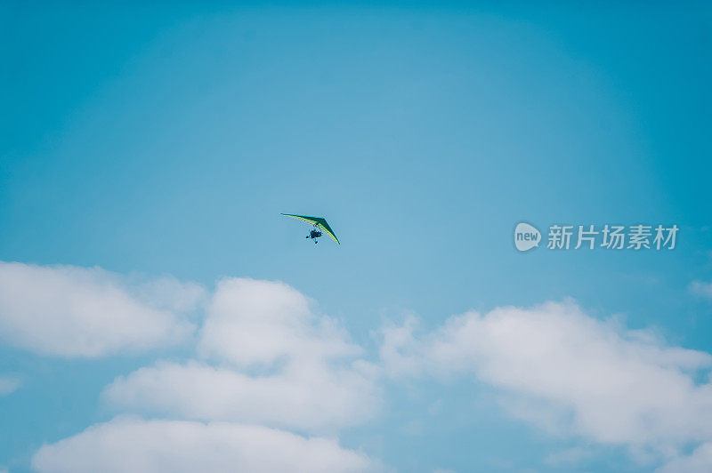 湛蓝明亮的天空上的电动悬挂滑翔机