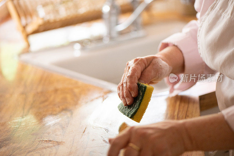 白人妇女用海绵擦拭厨房台面