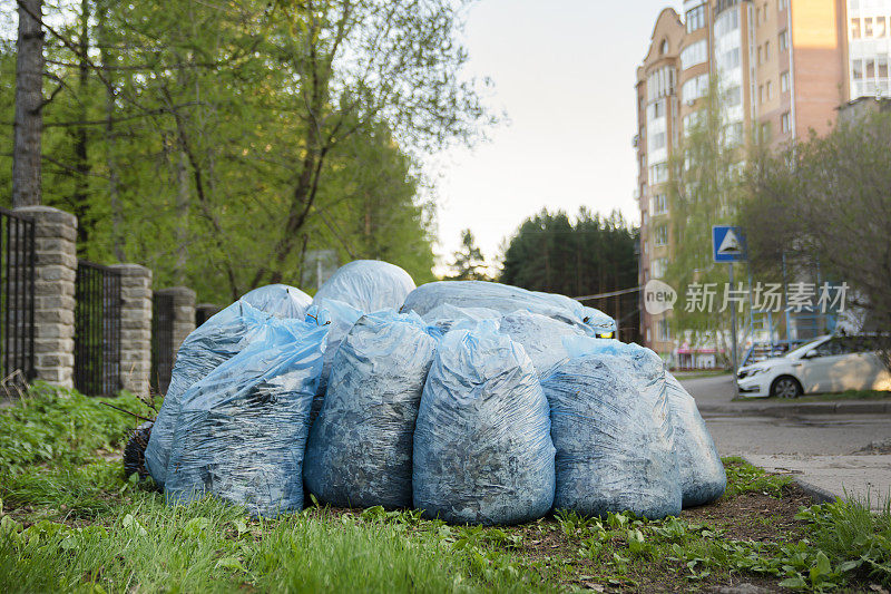 装着垃圾的塑料袋堆放在路边。清扫居民区和庭院