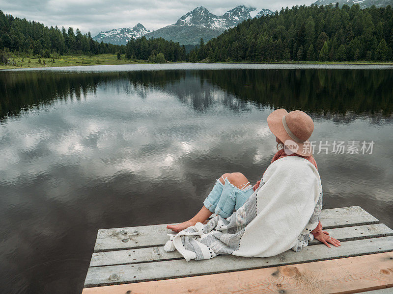 年轻女子在湖边码头休息