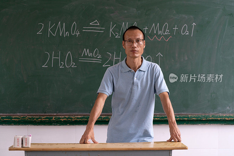 亚洲中年男教师在黑板前的正面肖像