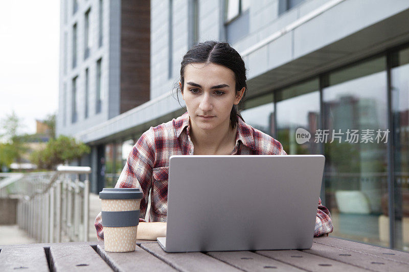 在校园里使用笔记本电脑的女大学生