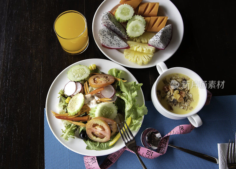俯视图的饮食餐早餐和蔬菜沙拉盘与卷尺和沙拉的健康食品。健康的生活方式概念。