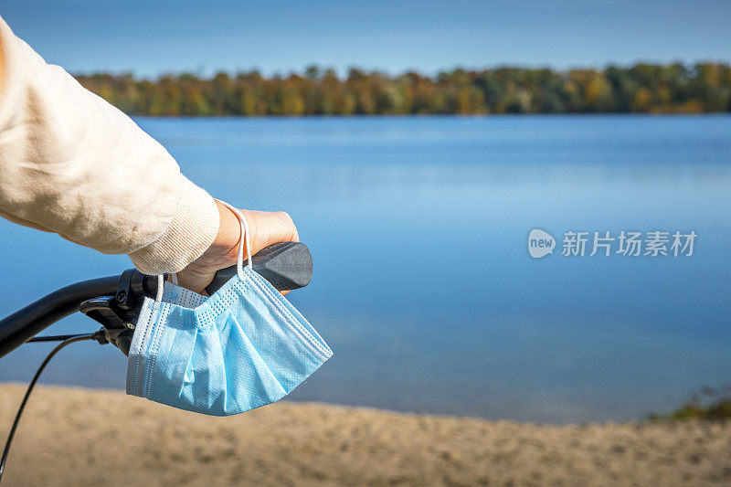 在自行车旅行期间，妇女的手上戴着一个保护面罩