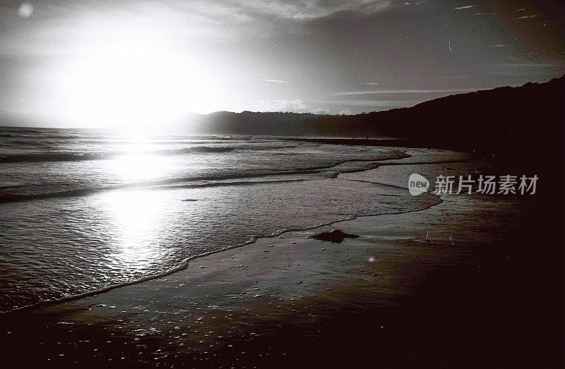 日落时海浪翻滚在海滩上