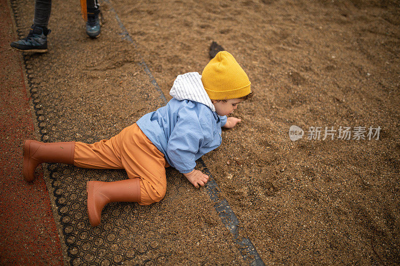 秋天的一天，顽皮的小男孩在操场上玩沙子