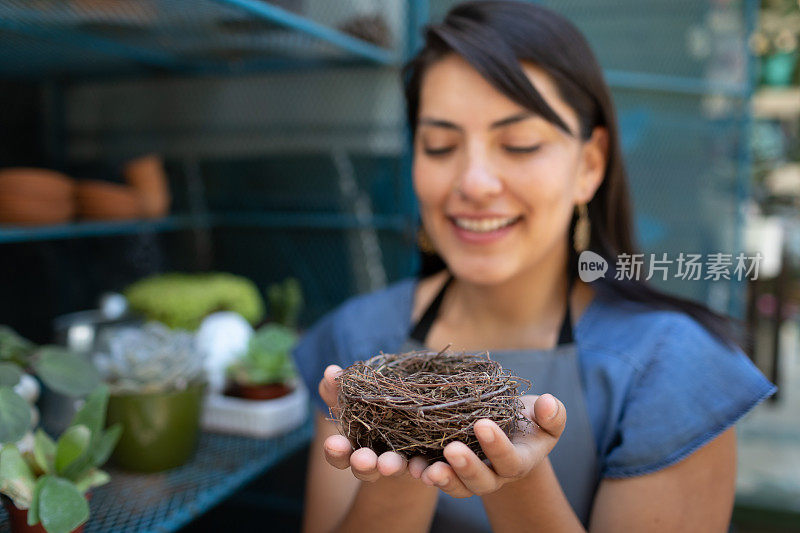 年轻女子微笑着欣赏一个空巢