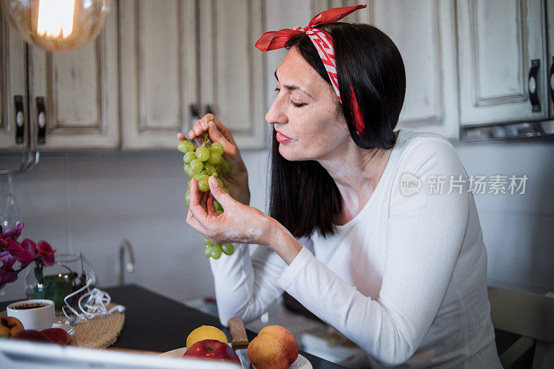 健康成熟的女人早餐吃健康食品——水果