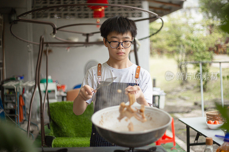 亚洲华人少年在后院厨房做视频，教烹饪广播。