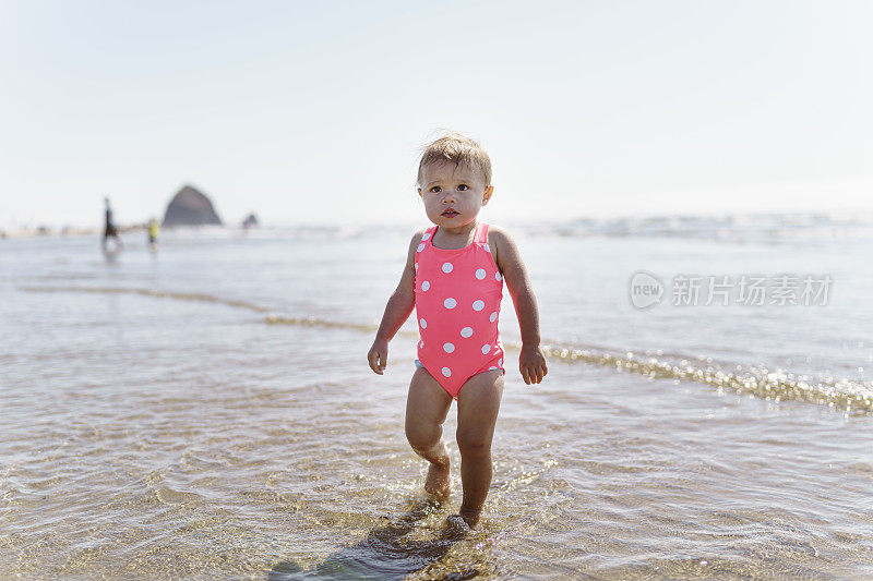 俄勒冈州坎农海滩，可爱的小女孩在水中玩耍