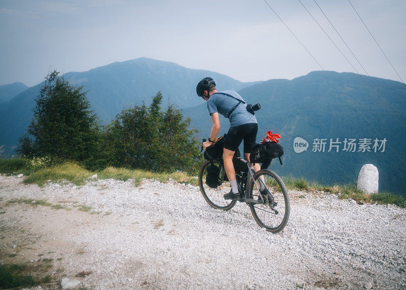 年轻人沿山路骑自行车的景象